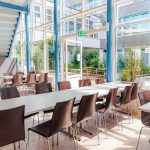 Innenansicht des Lernortes Paul-Bonatz-Straße mit Tischen und Stühlen.