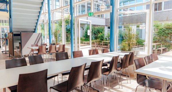 Innenansicht des Lernortes Paul-Bonatz-Straße mit Tischen und Stühlen.